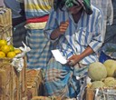 Man counting money - sale of orange & melons - Sadarghat, Dhaka - B. Etzold 02/2007